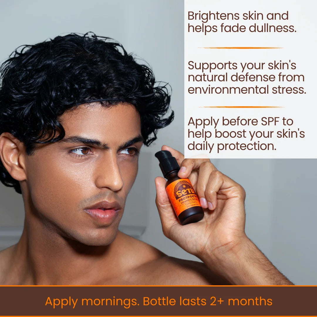 Vitamin C serum bottle held by male model, amber glass with black dropper cap