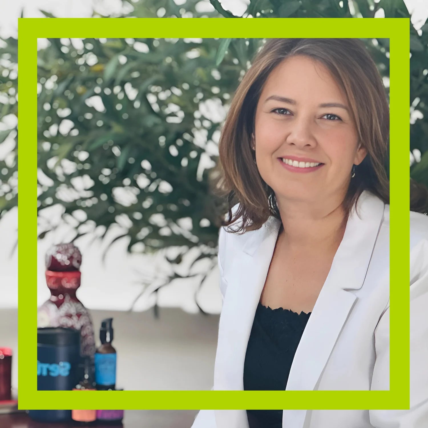 Dr Jennifer Aranda, Setu skincare co-founder in a white blazer standing in front of a green frame with blurred background