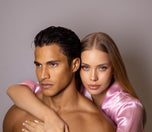 Man and woman embracing each other against a plain background