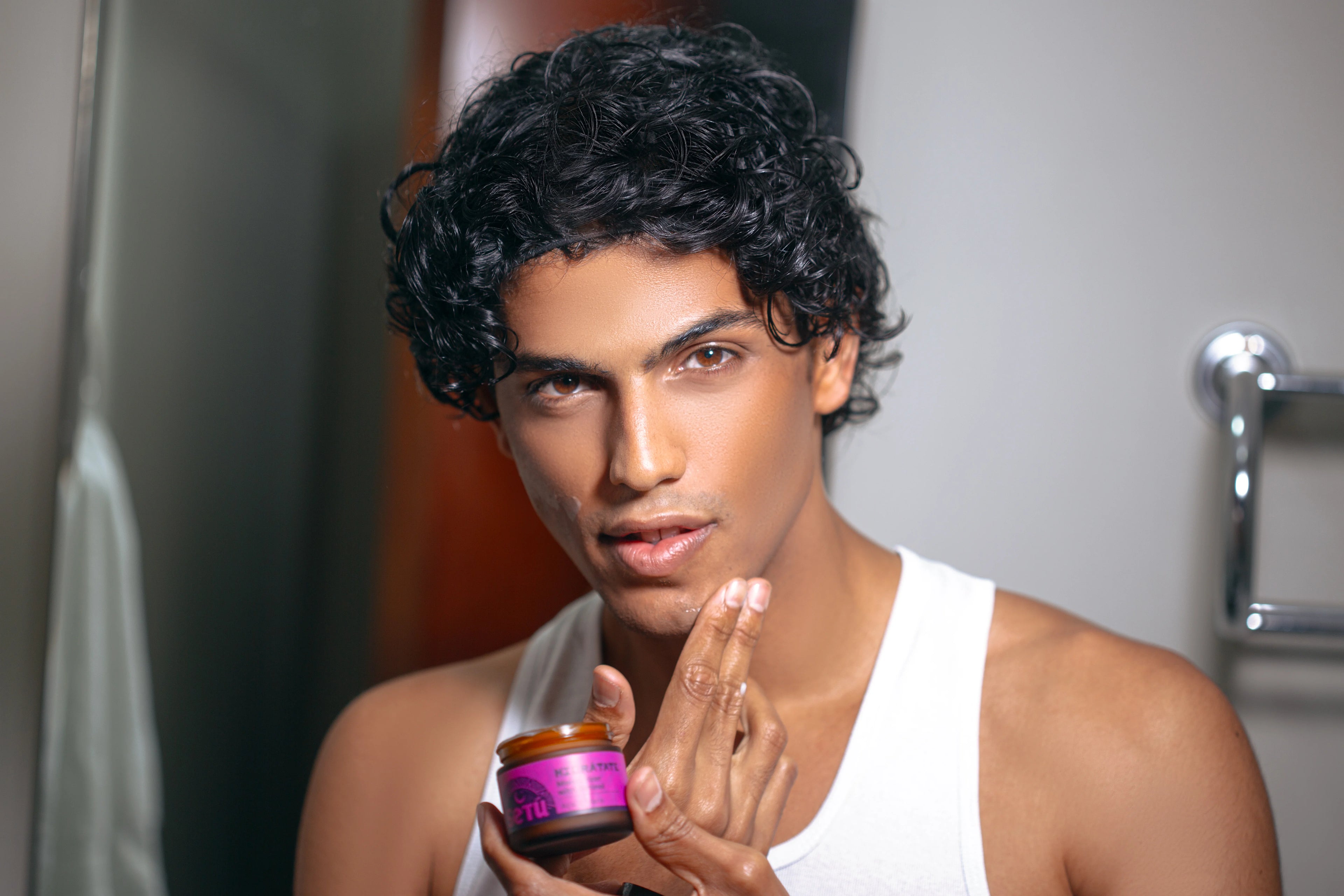 Man applying setu product in front of a mirror
